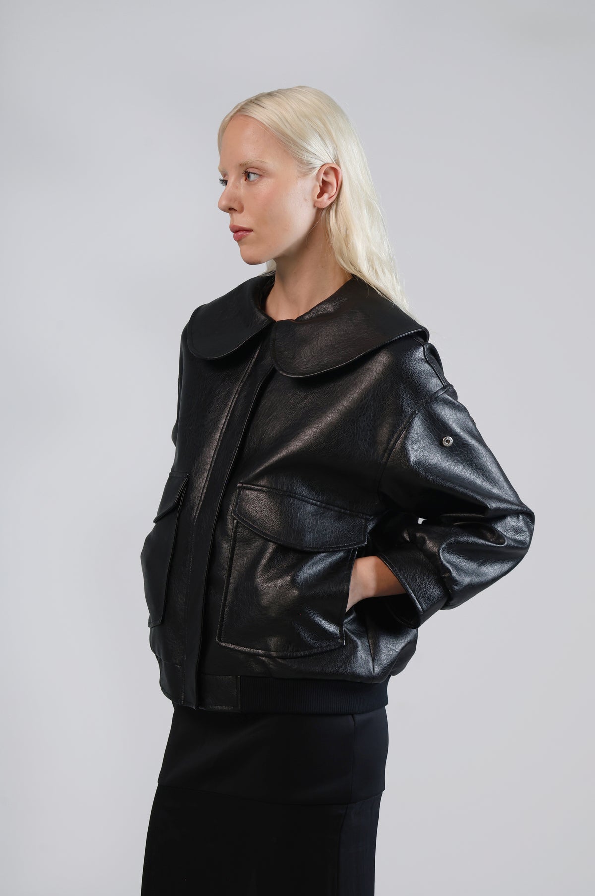 Jinnoir black faux leather jacket with a relaxed fit and wide sleeves, three-quarter view on model