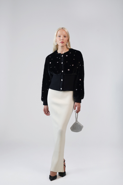 Pearle black faux fur cardigan jacket with pearlescent beads, front view on model with a cream ribbed maxi skirt