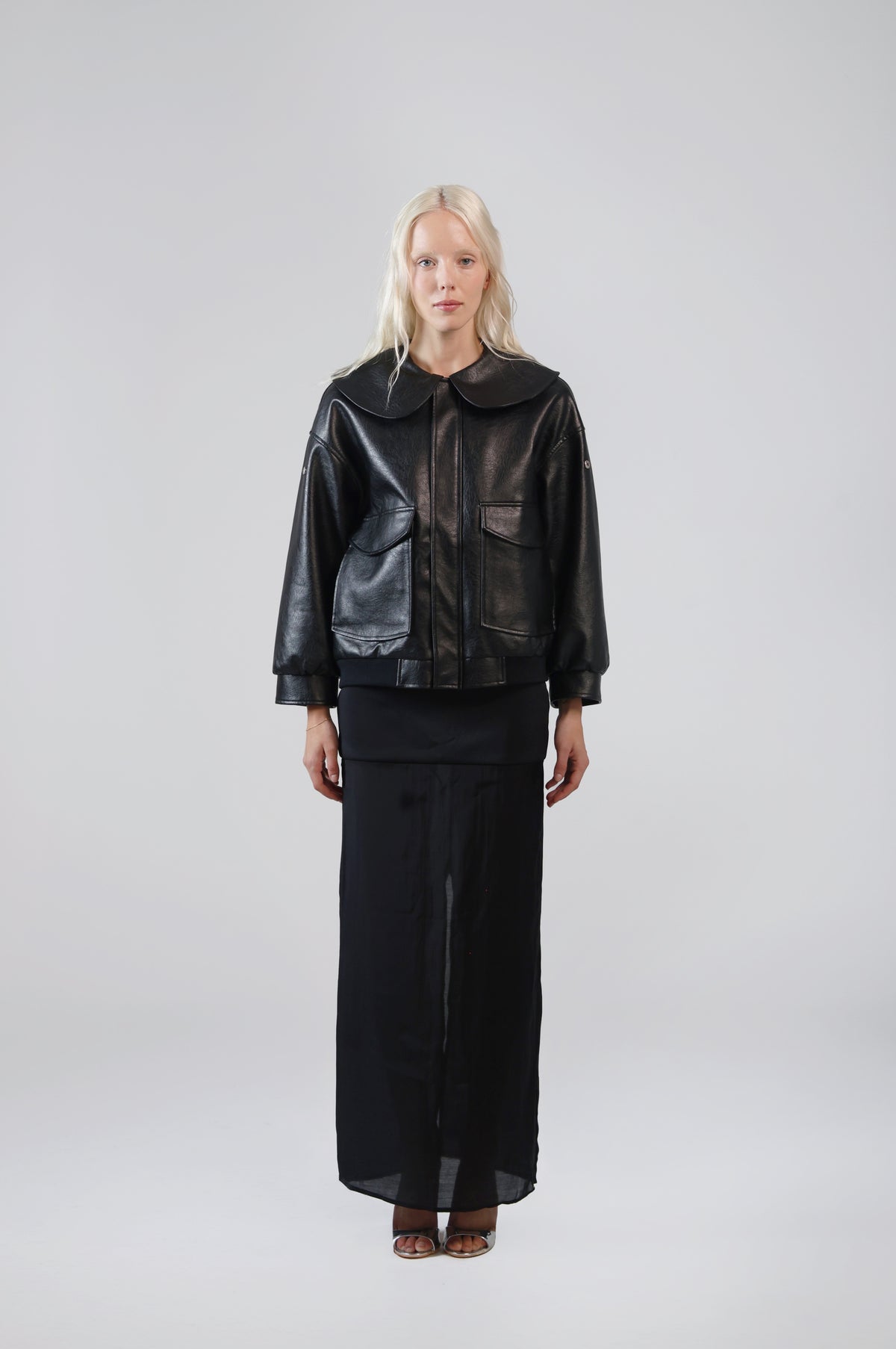 Jinnoir black faux leather jacket with an oversized Peter Pan collar, front view on model