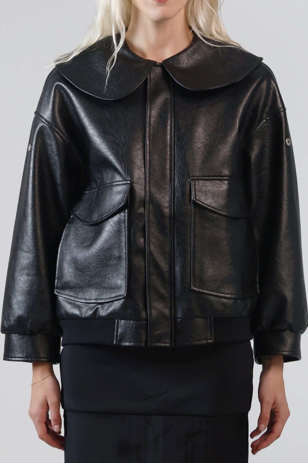 Close-up of the Jinnoir jacket's oversized Peter Pan collar and patch pockets in black faux leather
