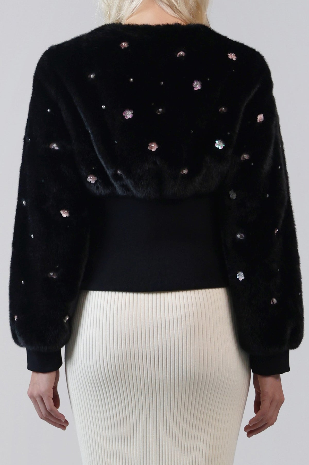 Close-up of the back of the Pearle cardigan jacket, with embellished faux fur and a cinched knit waistband