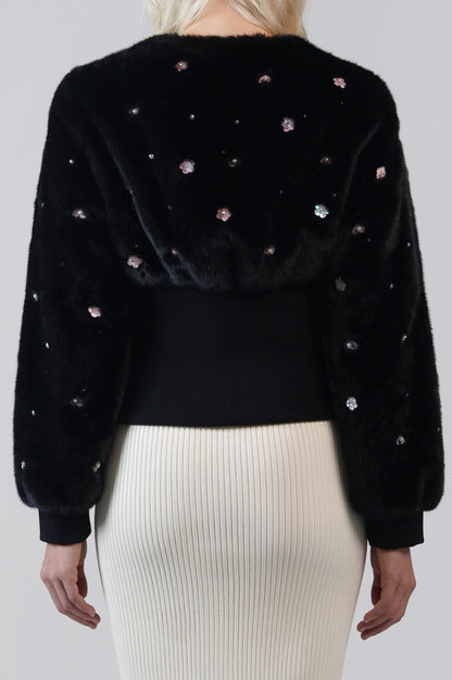 Close-up of the back of the Pearle cardigan jacket, with embellished faux fur and a cinched knit waistband