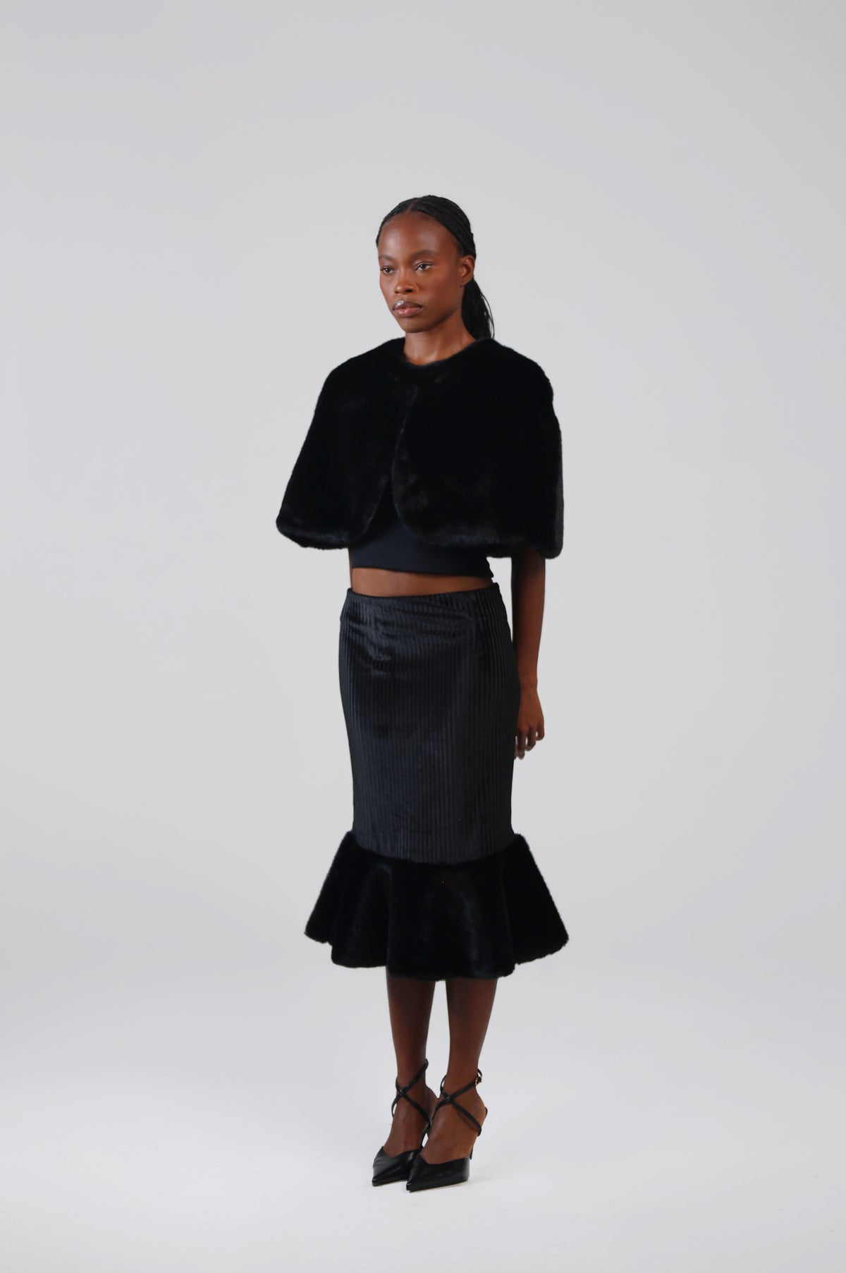Black velvet midi skirt with faux fur flounce, three-quarter view on model