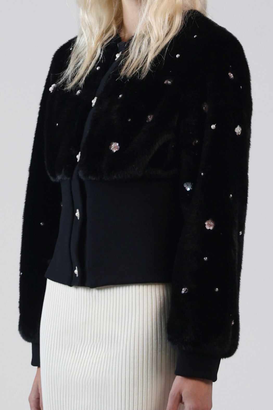 Close-up of hand-sewn pearlescent beads and iridescent flower beads on the Pearle cardigan's black faux fur