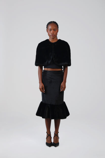 Black velvet midi skirt with faux fur flounce, front view on model with the faux fur capelet