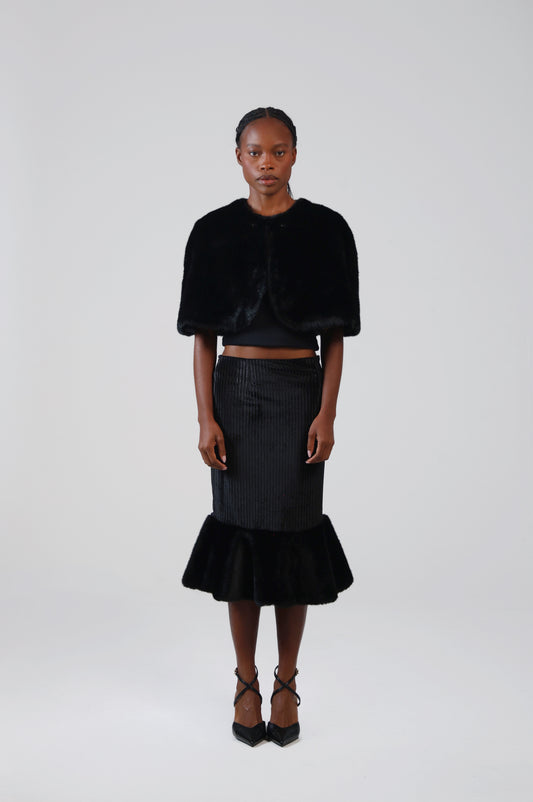 Black velvet midi skirt with faux fur flounce, front view on model with the faux fur capelet