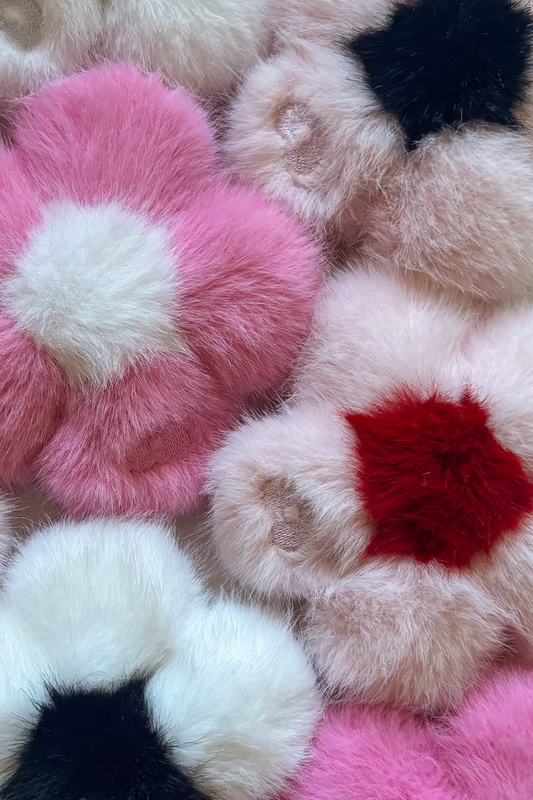 Close-up of a pile of Blume II faux fur flower charms in pink, white, black and red