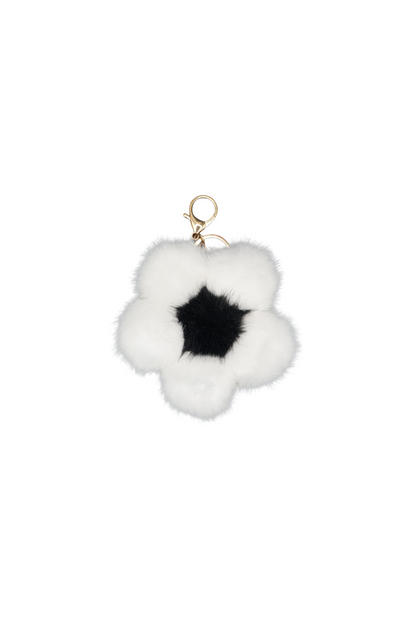 Single dalmatian white faux fur flower charm on a metal keychain, worn as a bag charm