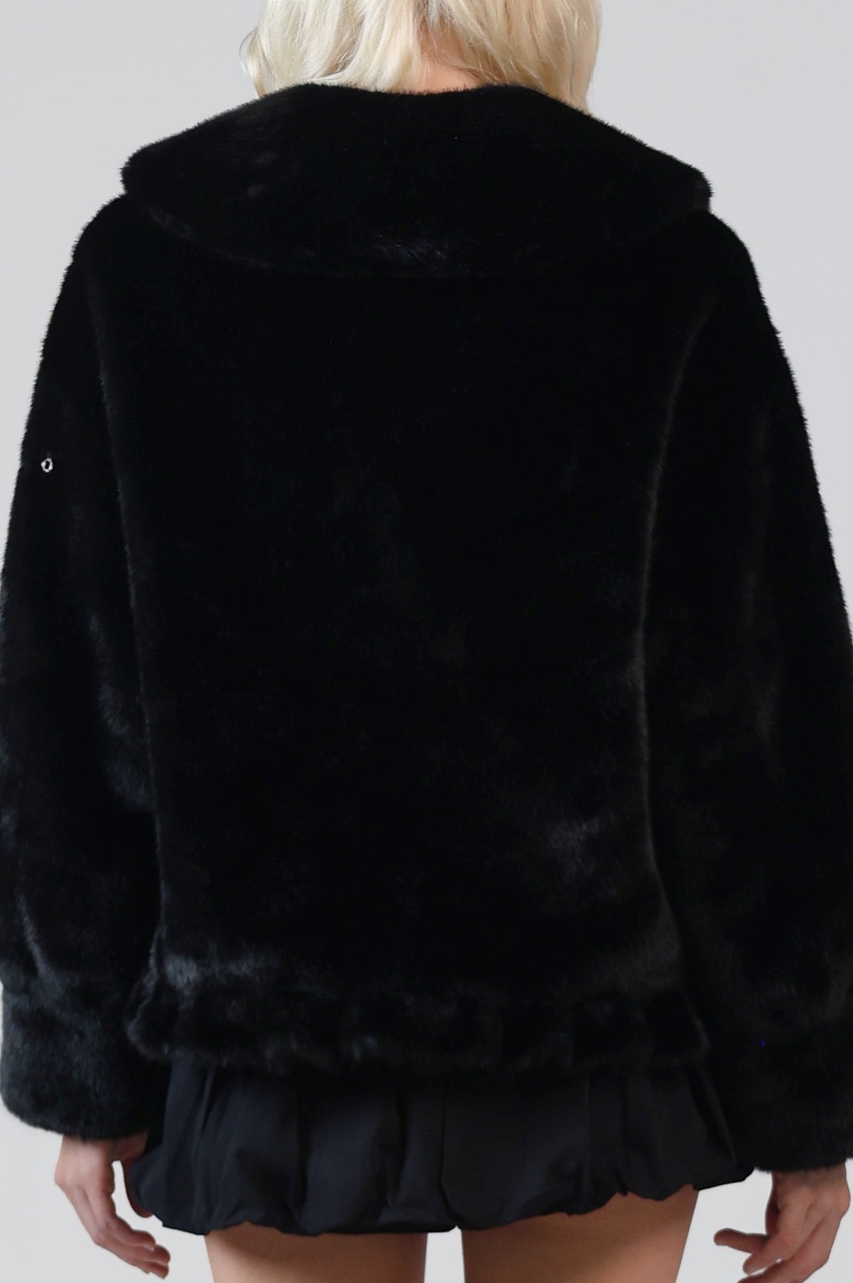 Close-up of the back of the Jinnette jacket, showing the Peter Pan collar, peplum hem and a sleeve snap
