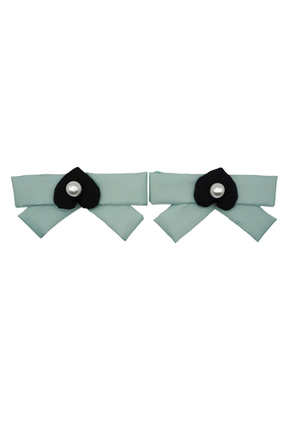 Pair of mint green bow charms, each centered with a black mamu heart logo and a pearlescent bead